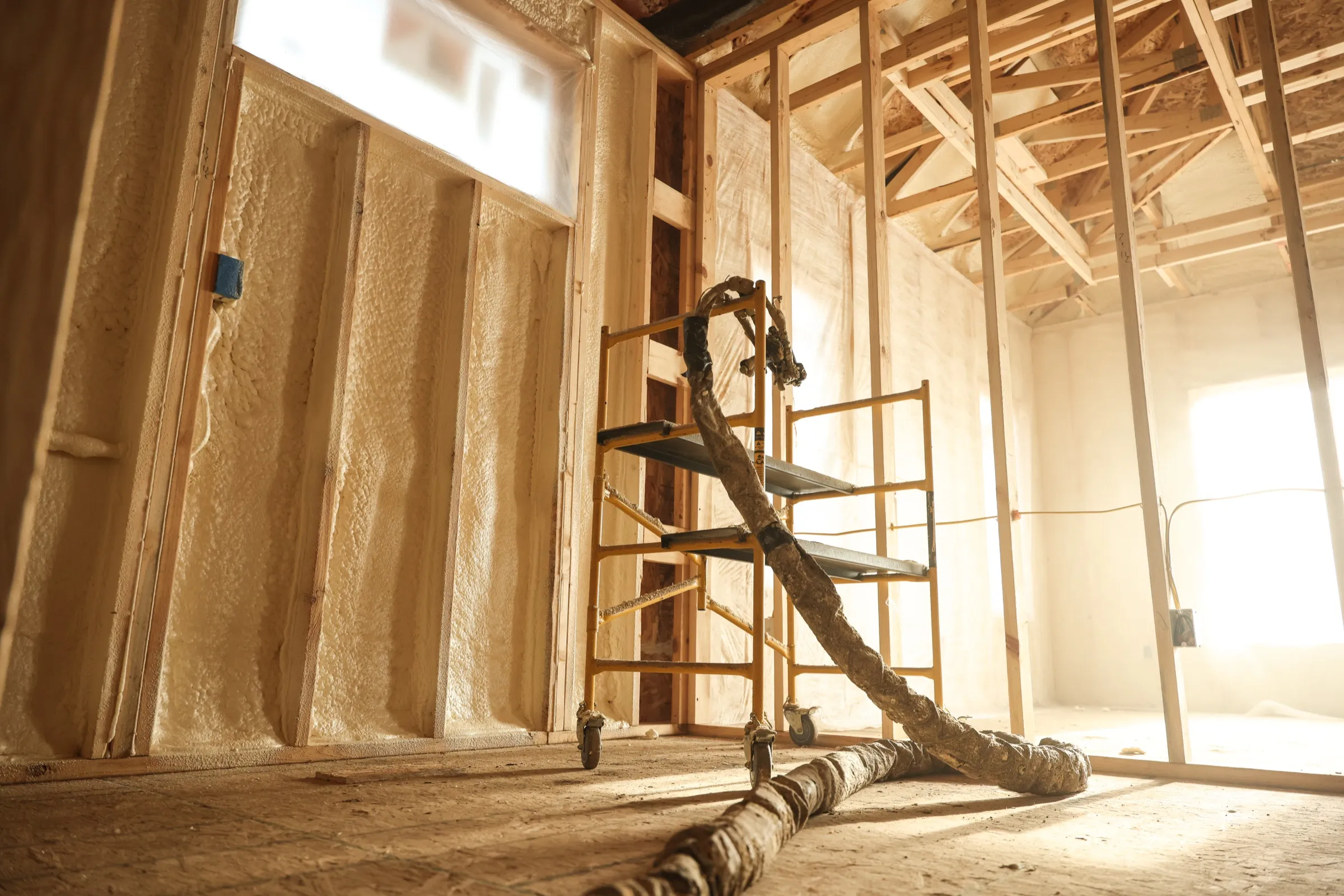 Professional installer applying spray foam insulation in an Arizona building